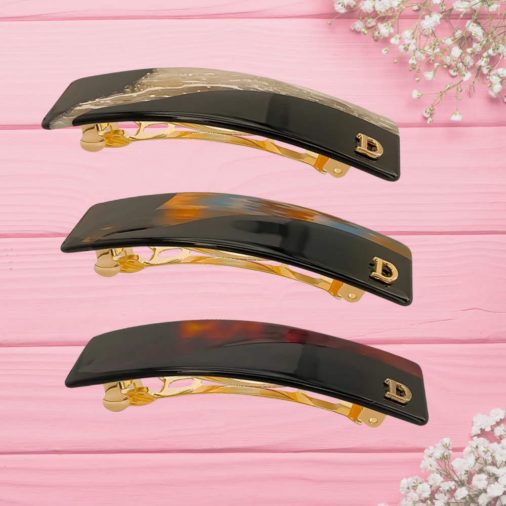 3 barrettes brune exposées sur table rose