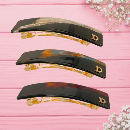 3 barrettes brune exposées sur table rose