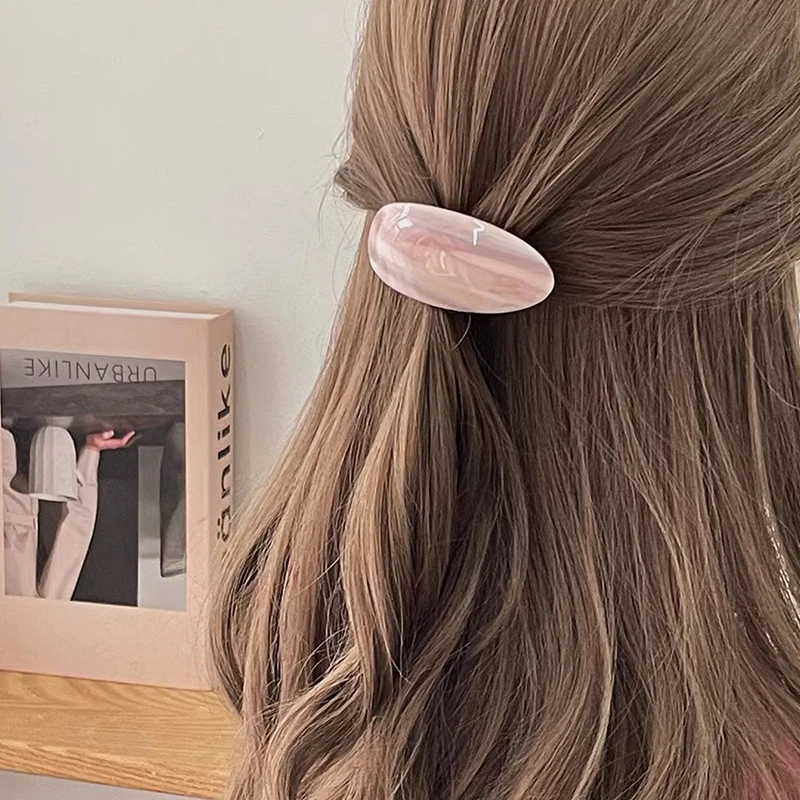barrette cheveux rose sur tête de femme demi queue de cheval