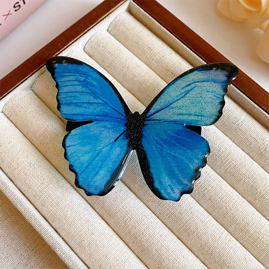 barrette pour les cheveux exposée sur table papillon bleu