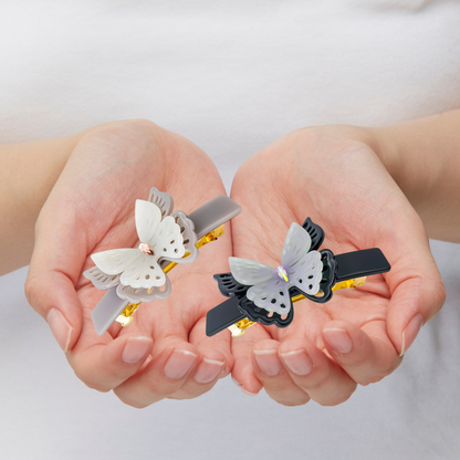 femme a dans ses mains barrettes papillons noir gris