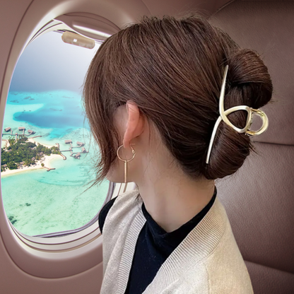 femme en avion porte pince a cheveux nœud dore