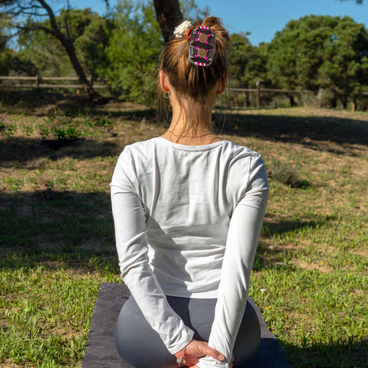 femme fait du yoga dans pré barrette dans ses cheveux