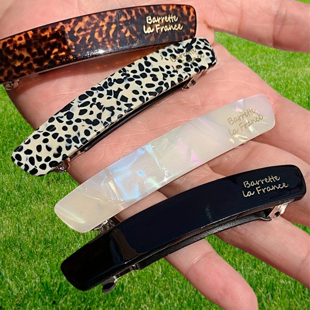 femme montre barrette cheveux dans sa main