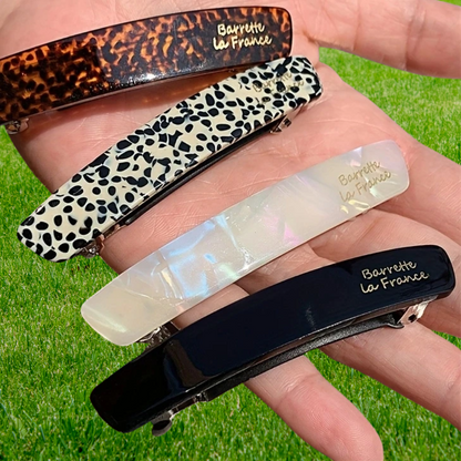 femme montre barrette cheveux dans sa main