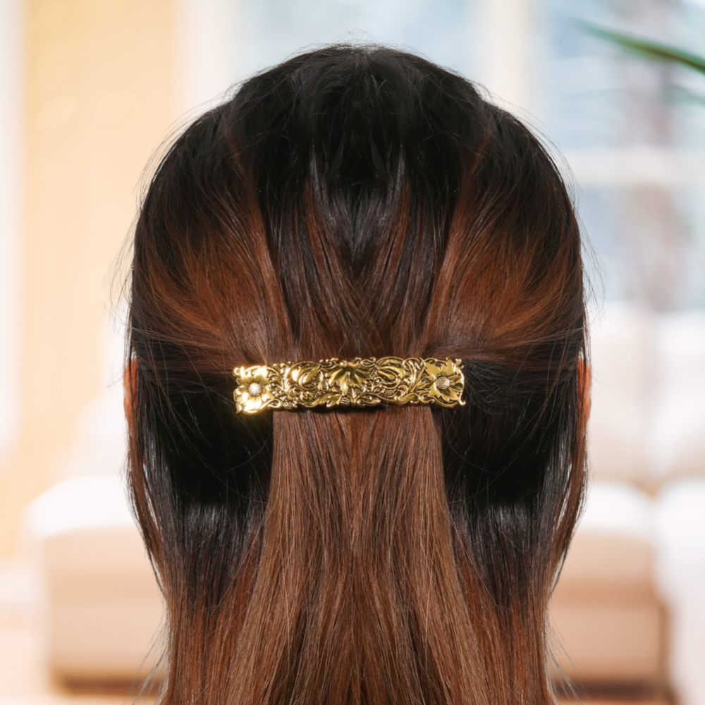 femme porte barrette pour les cheveux couleur dorée