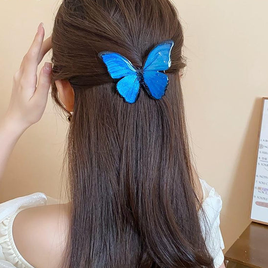 femme porte barrette pour les cheveux papillon bleu