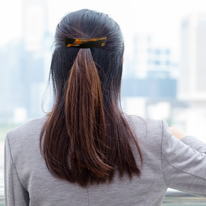 femme porte barrettes brun rouge regarde la ville