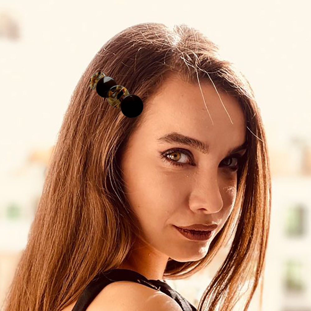 femme porte dans ses cheveux barrettes café