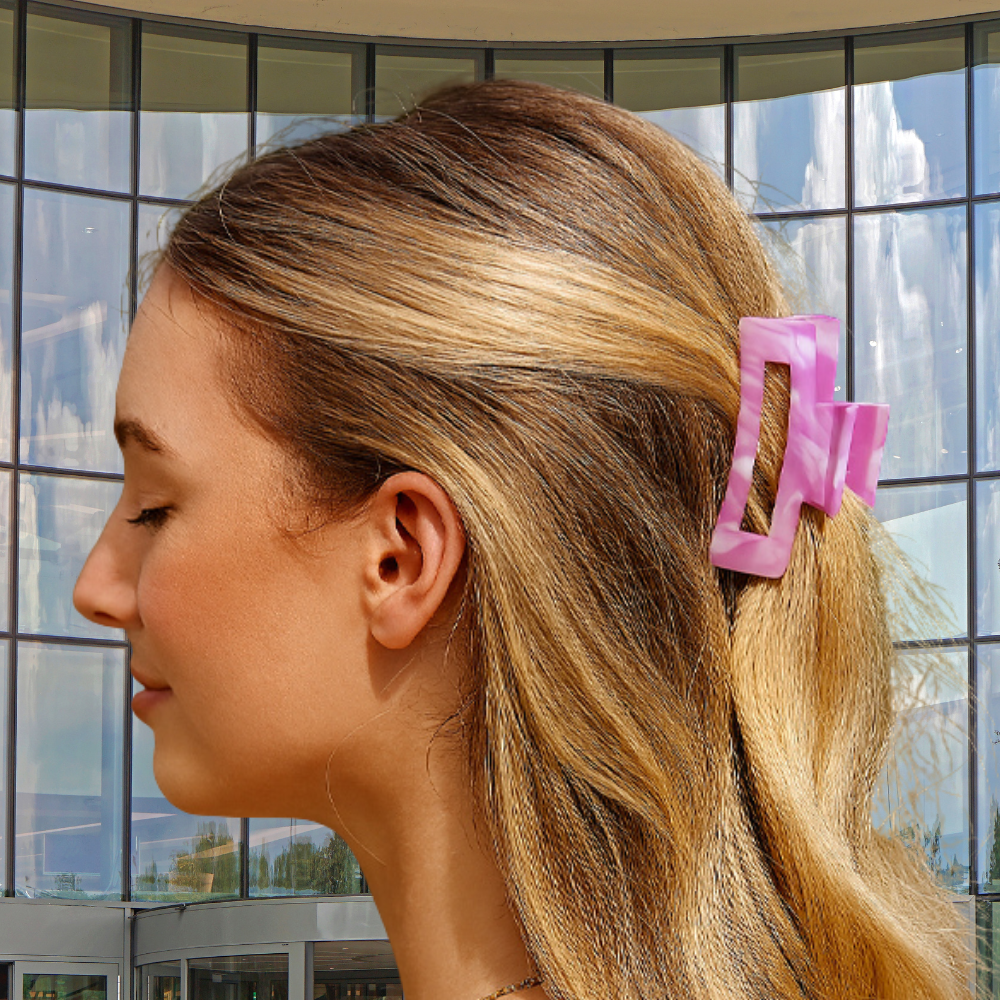 femme porte pince a cheveux rose devant fenêtre