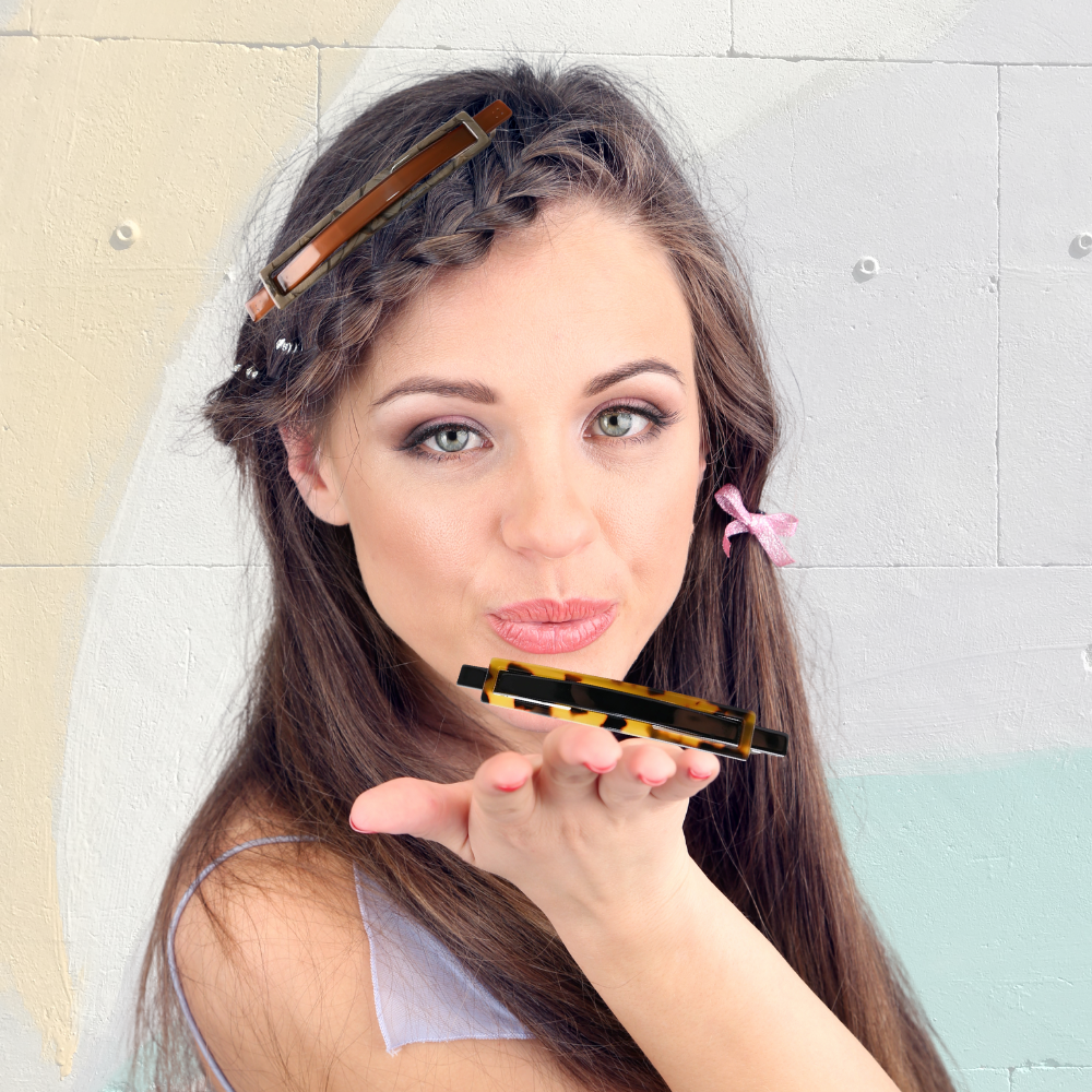 jolie fille tient dans sa main barrette pour les cheveux